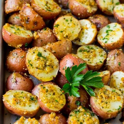Oven roasted potatoes coated in garlic and herbs, then garnished with parsley.