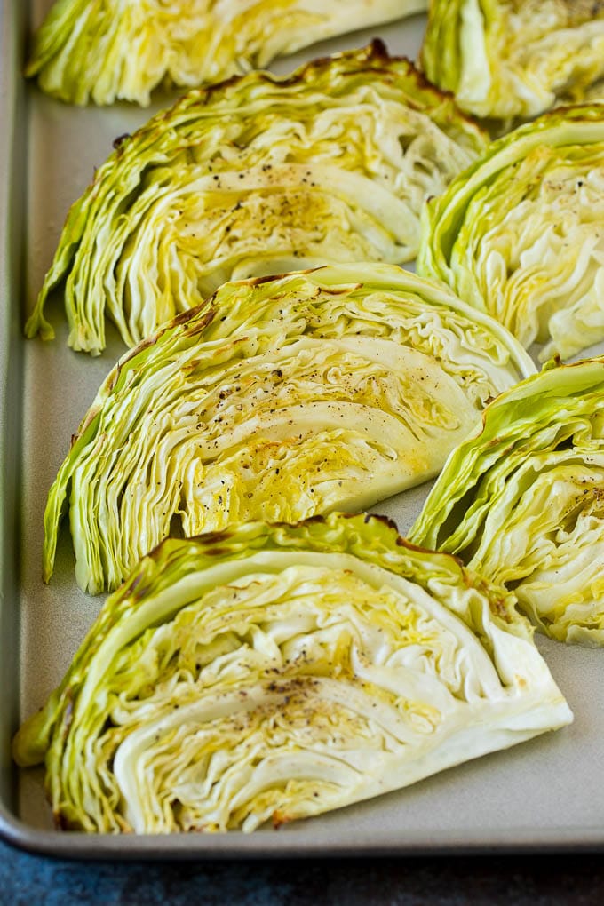 Cooked cabbage wedges laying on a sheet pan.