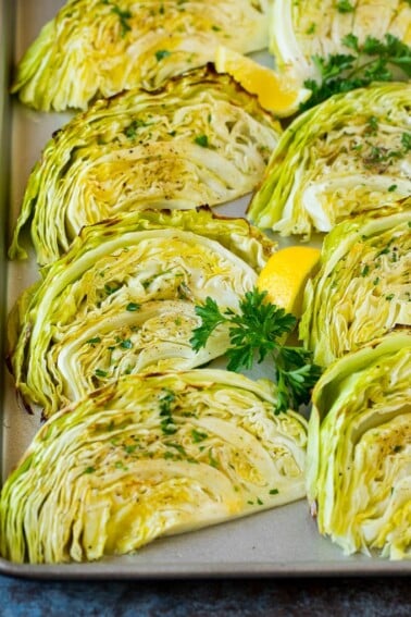 Roasted cabbage on a pan topped with fresh parsley.