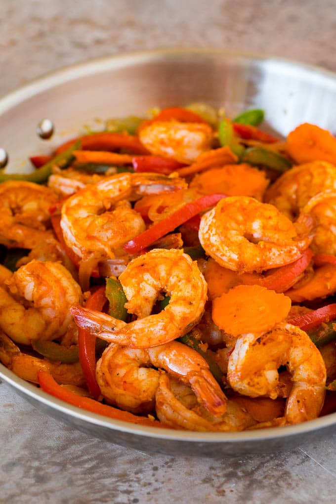 Shrimp, curry paste and vegetables in a pan.