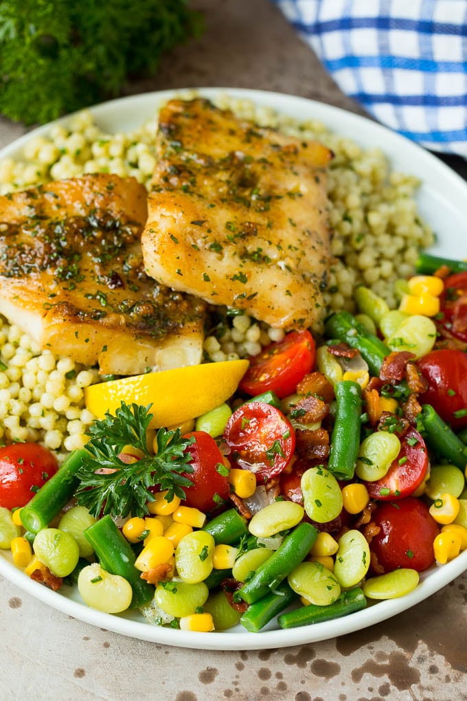 Succotash served on a plate with fish and couscous.