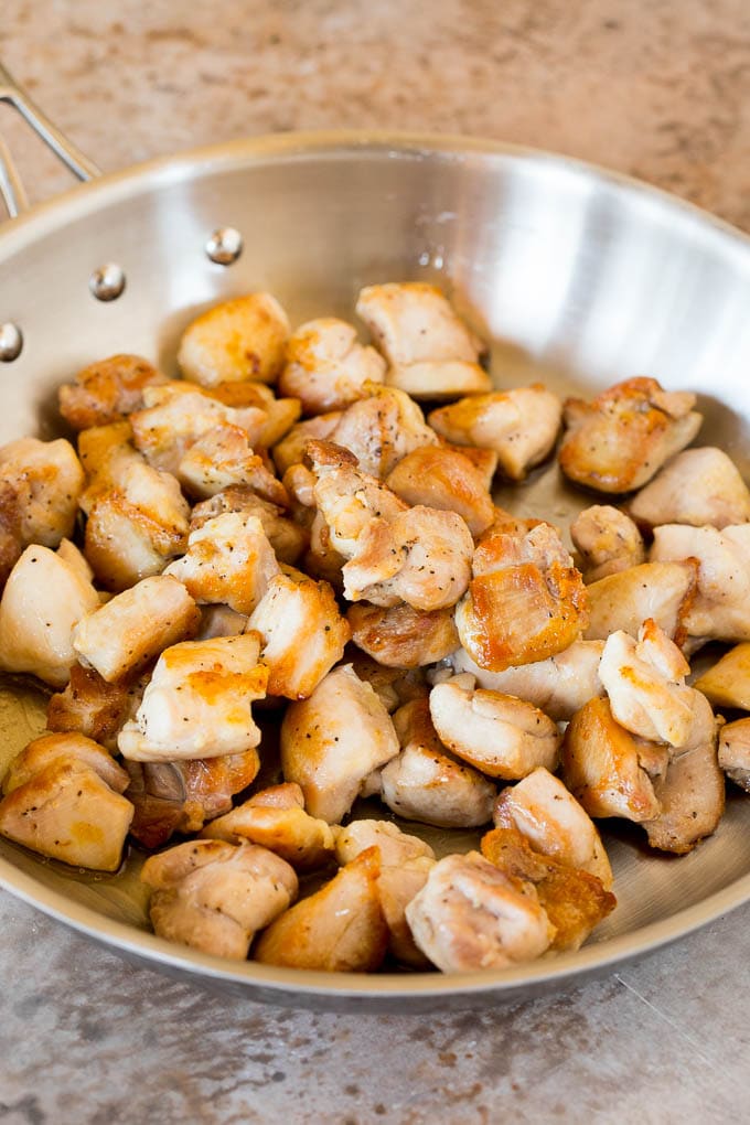 Seared chicken pieces in a skillet.