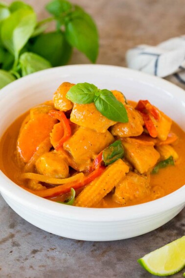 A bowl of Thai chicken curry topped with fresh basil.