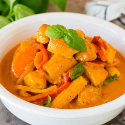 A bowl of Thai chicken curry topped with fresh basil.