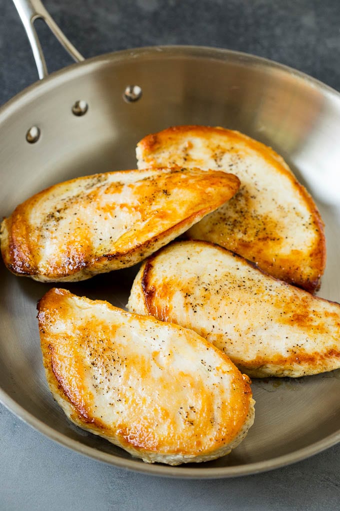 Seared chicken breasts in a pan.