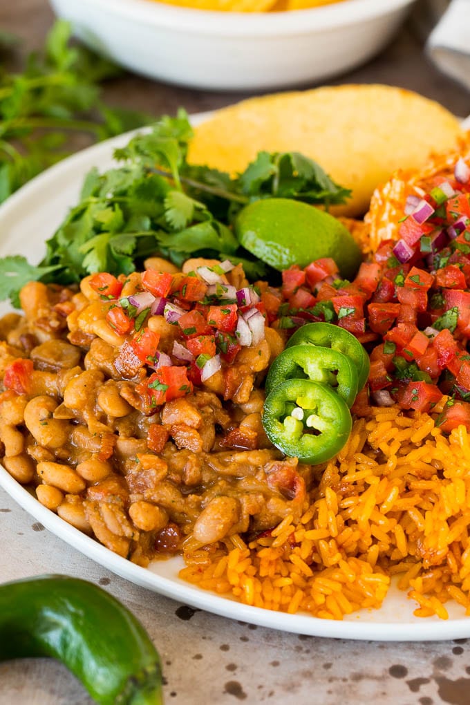 Charro beans served with rice, tortillas and salsa.