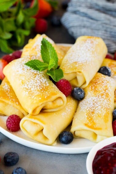 Cheese blintzes garnished with powdered sugar and berries.