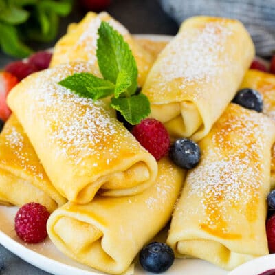 Cheese blintzes garnished with powdered sugar and berries.