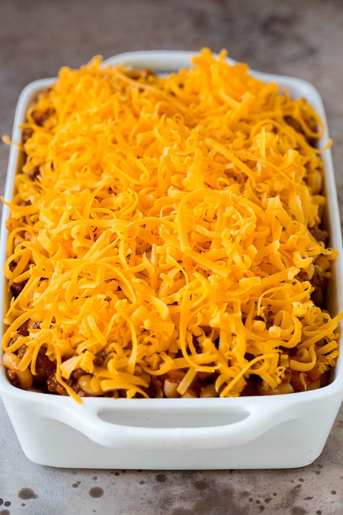 A casserole dish of pasta and beef topped with shredded cheese.