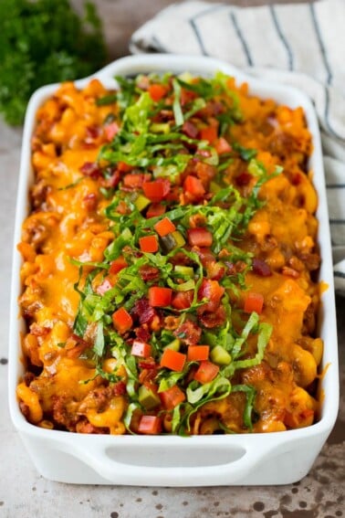 Cheeseburger casserole with ground beef and pasta, topped with melted cheese, bacon and tomatoes.