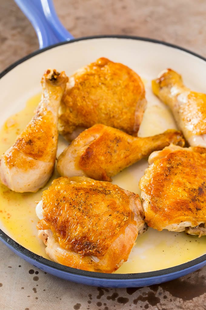 Browned chicken pieces in a skillet.