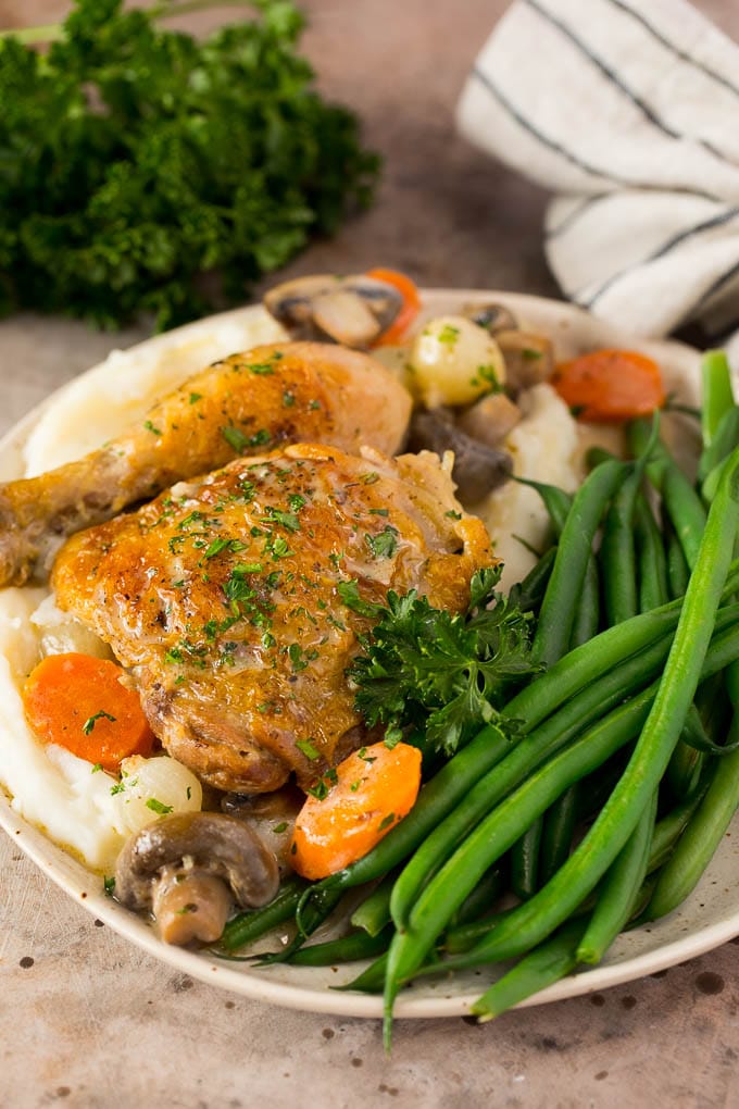 A plate of chicken fricassee served with mashed potatoes and green beans.