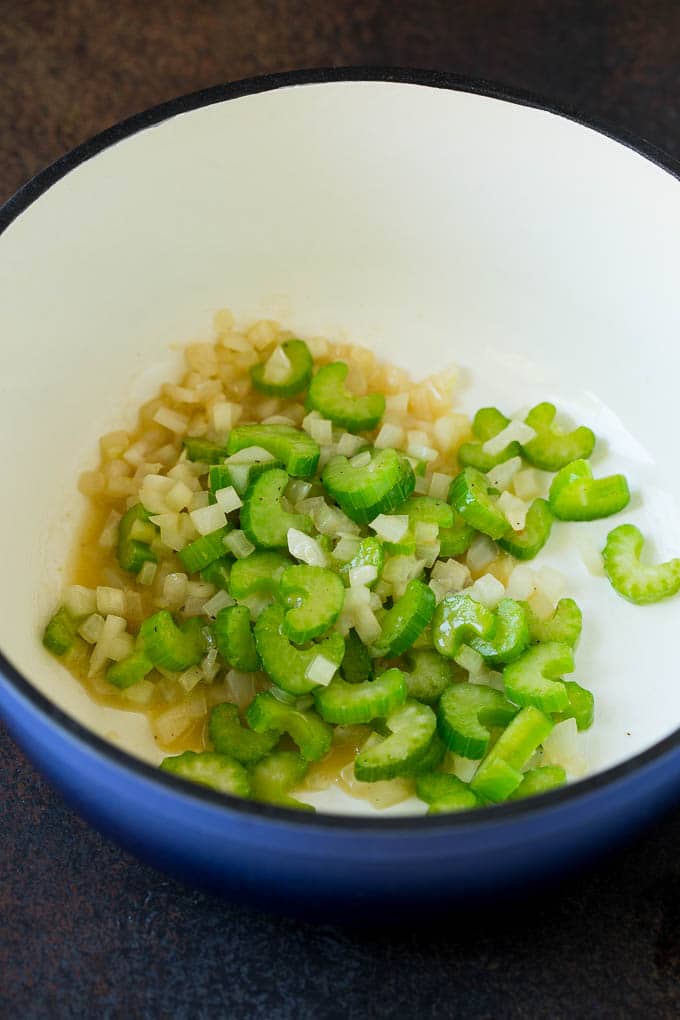 Sauteed celery and onions in a pot.