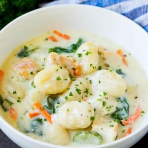 A bowl of creamy gnocchi soup topped with chopped parsley.