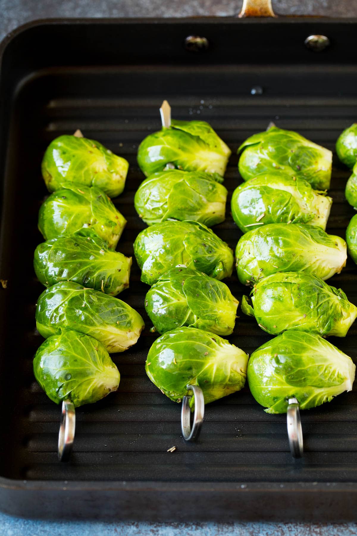 Brussels sprouts on skewers on a grill pan.