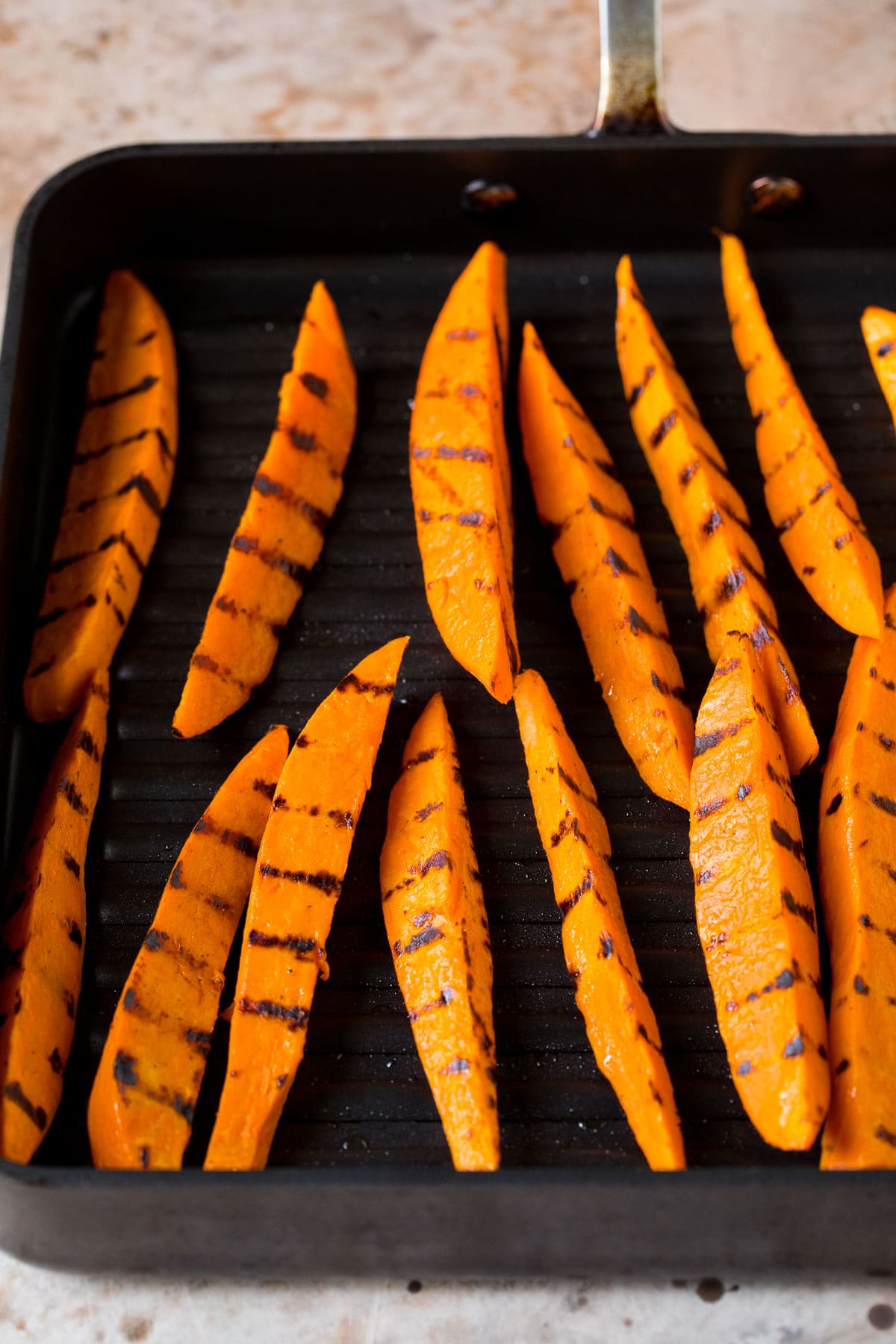 Sweet potato wedges cooked on a grill pan.