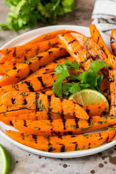 A plate of grilled sweet potatoes topped with cilantro lime dressing.