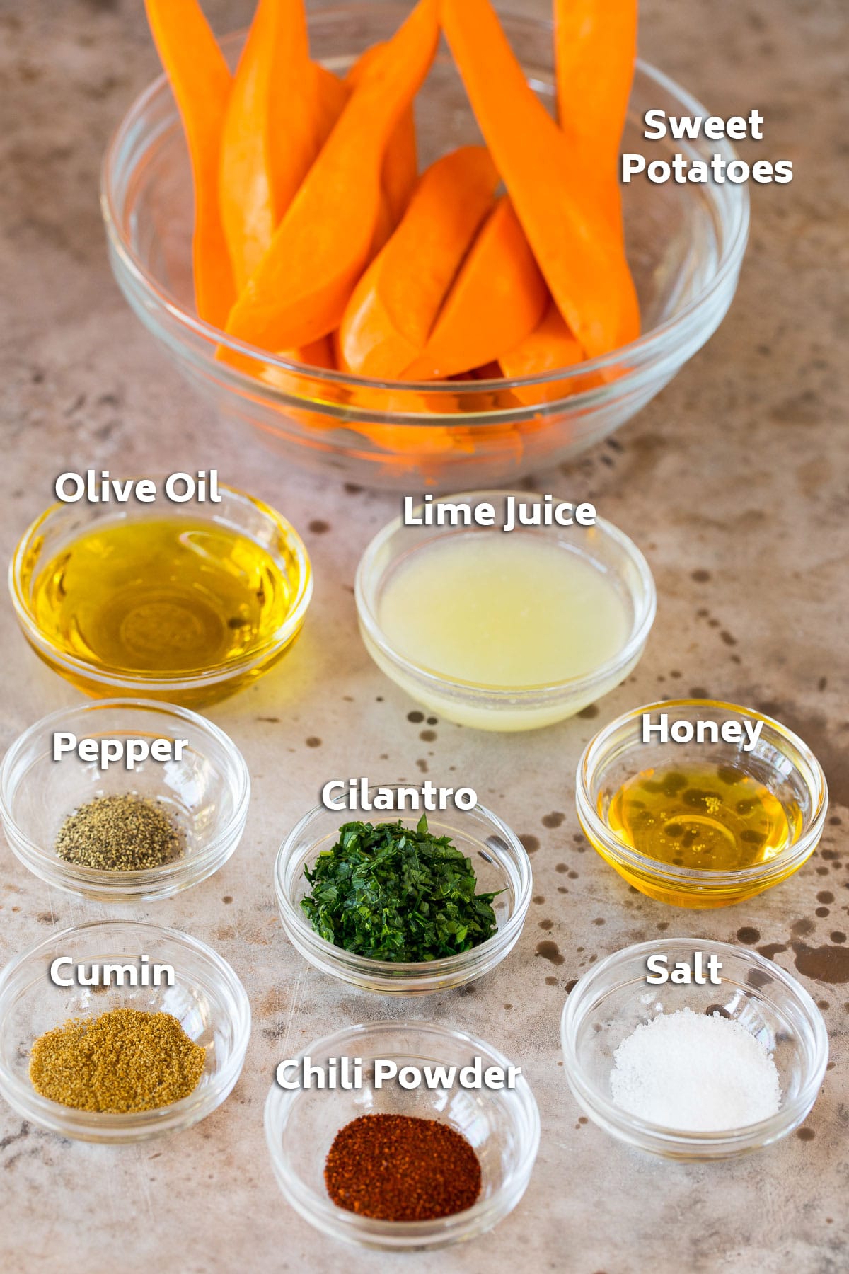 Bowls of sweet potatoes, olive oil, herbs and spices.