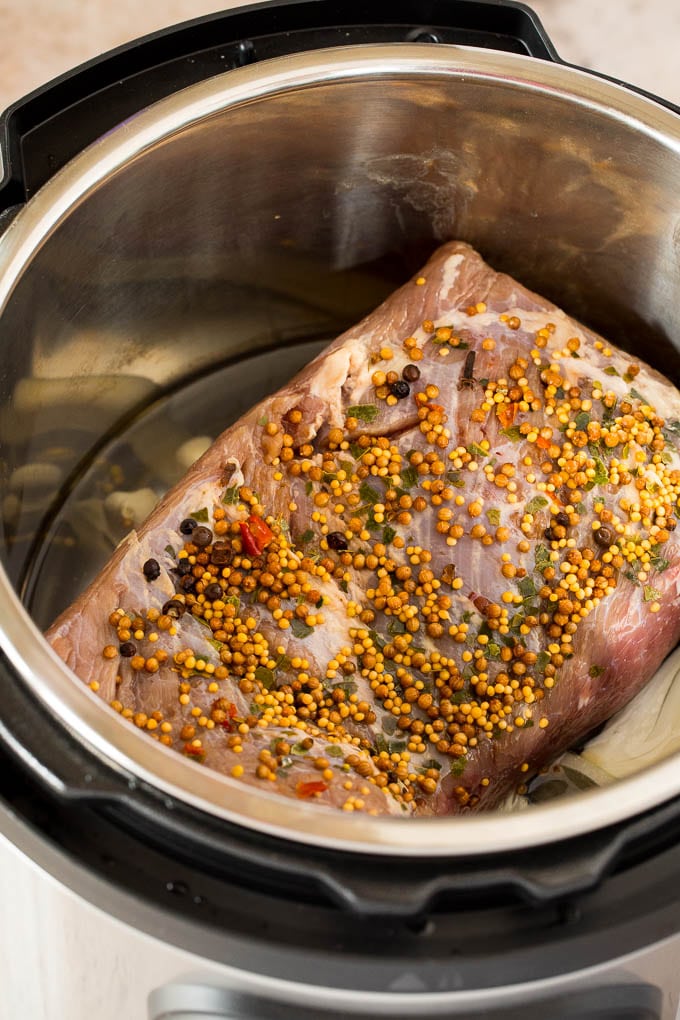 A raw corned beef in a pressure cooker.