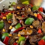 Kung pao beef with peppers and peanuts in a saute pan.