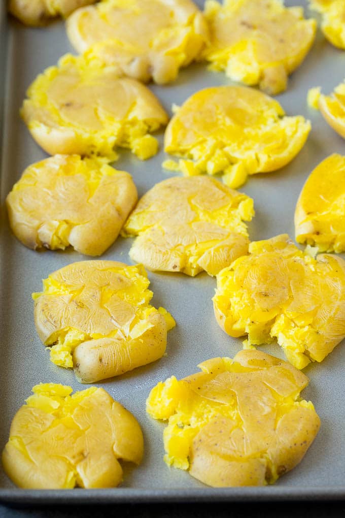 Flattened potatoes on a sheet pan.