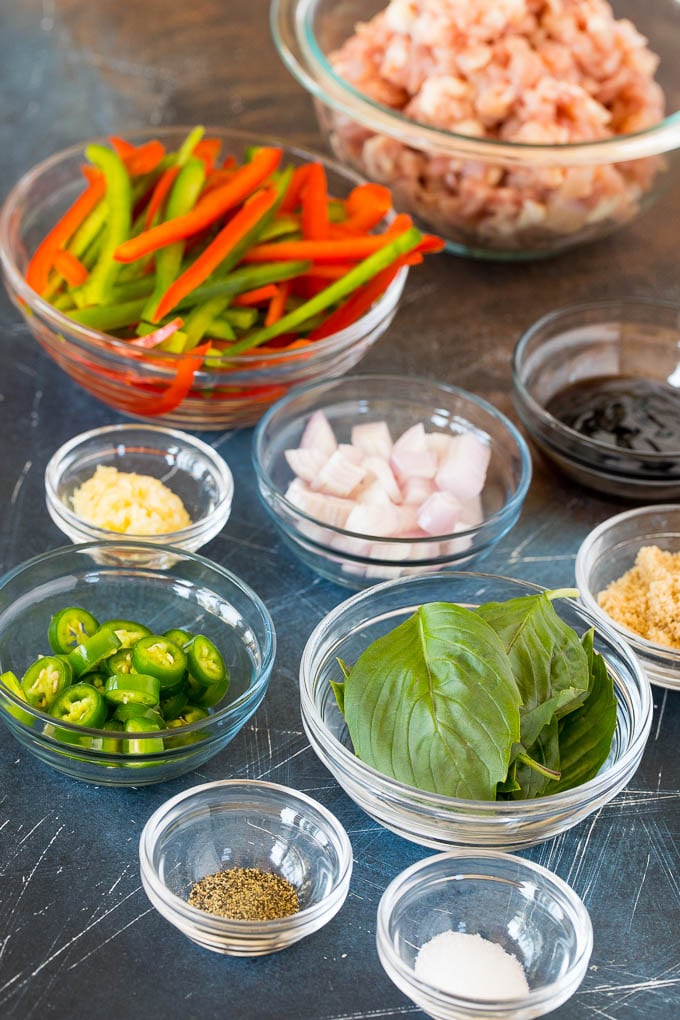 Bowls of ingredients including bell peppers, basil leaves, serrano chilies and minced chicken.