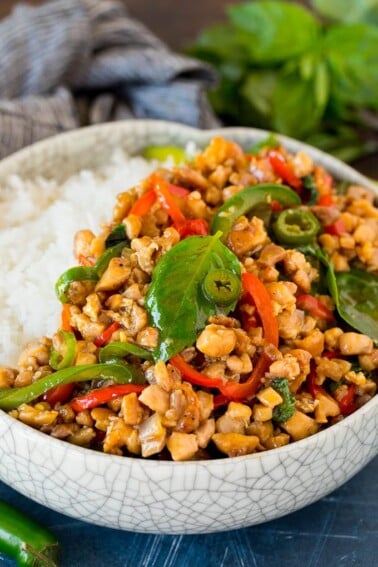 A bowl of Thai basil chicken served over rice.