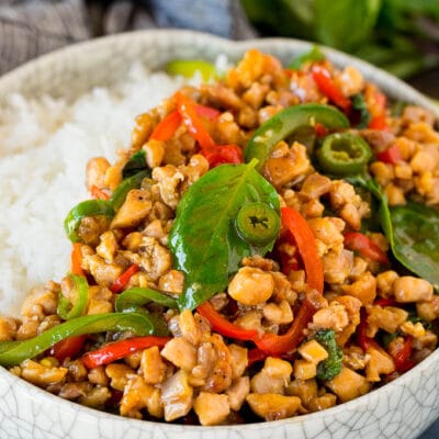 A bowl of Thai basil chicken served over rice.