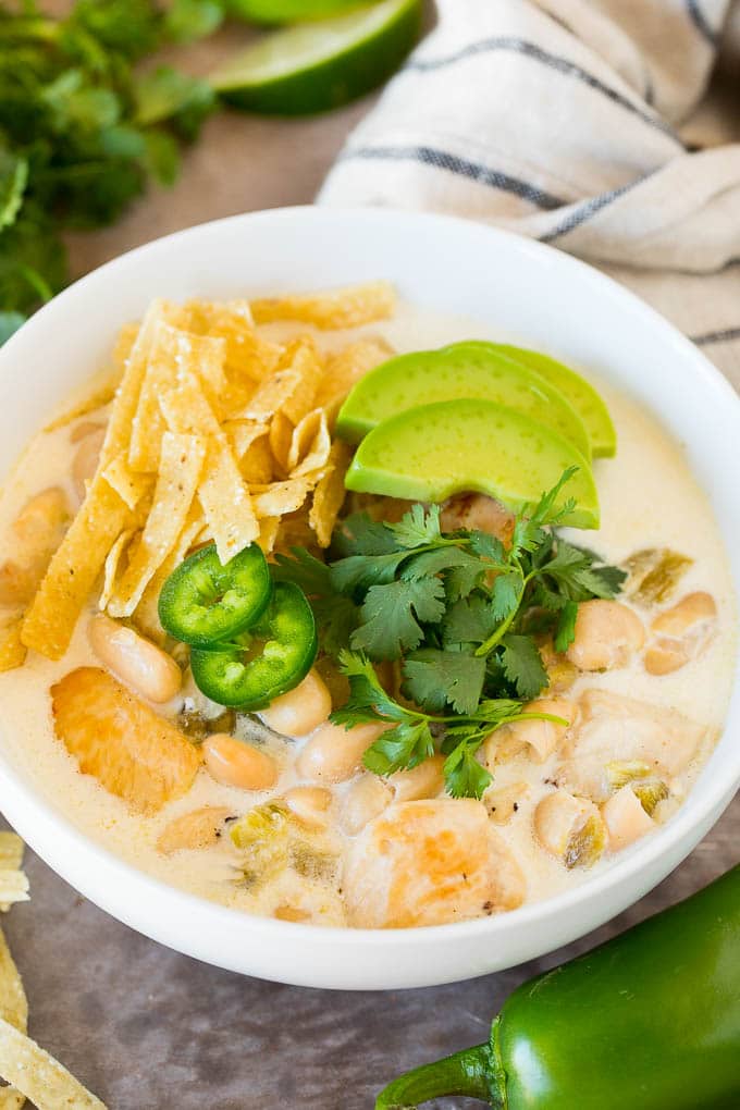 This white chicken chili is a creamy blend of chicken, chilies, beans and spices, all simmered together White chicken chili topped with tortilla strips, cilantro and avocado.