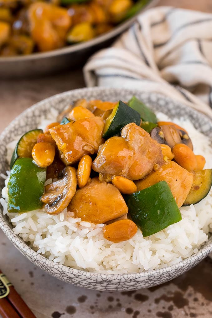 Almond chicken served over steamed rice in a bowl.