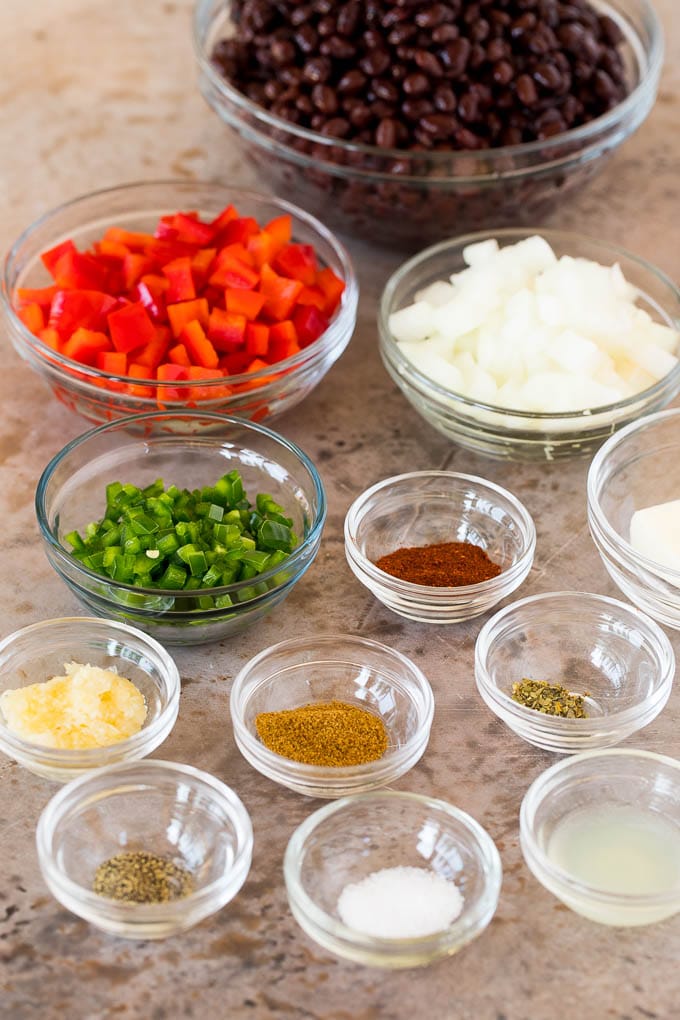 Glass bowls of ingredients including black beans, vegetables and spices.