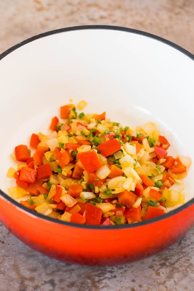 Sauteed onions, bell peppers and jalapenos in a pot.