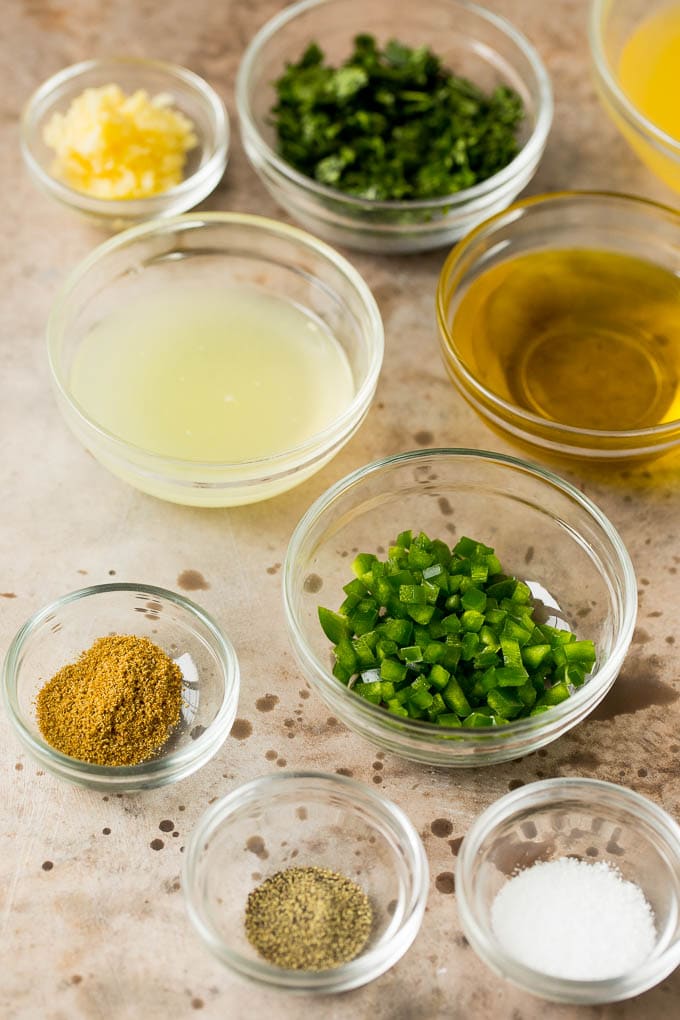 Bowls with lime juice, orange juice, seasonings, jalapeno and cilantro.