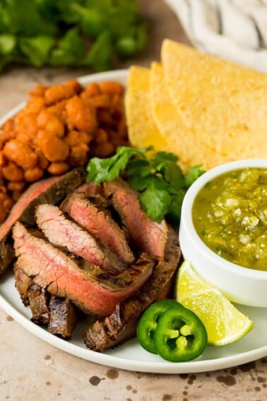 Grilled steak in carne asada marinade served with salsa, tortillas and beans.