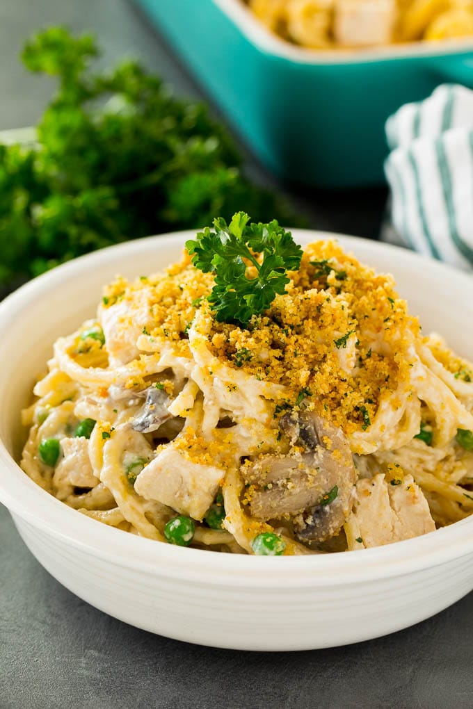 A bowl of chicken tetrazzini topped with breadcrumbs and parsley.