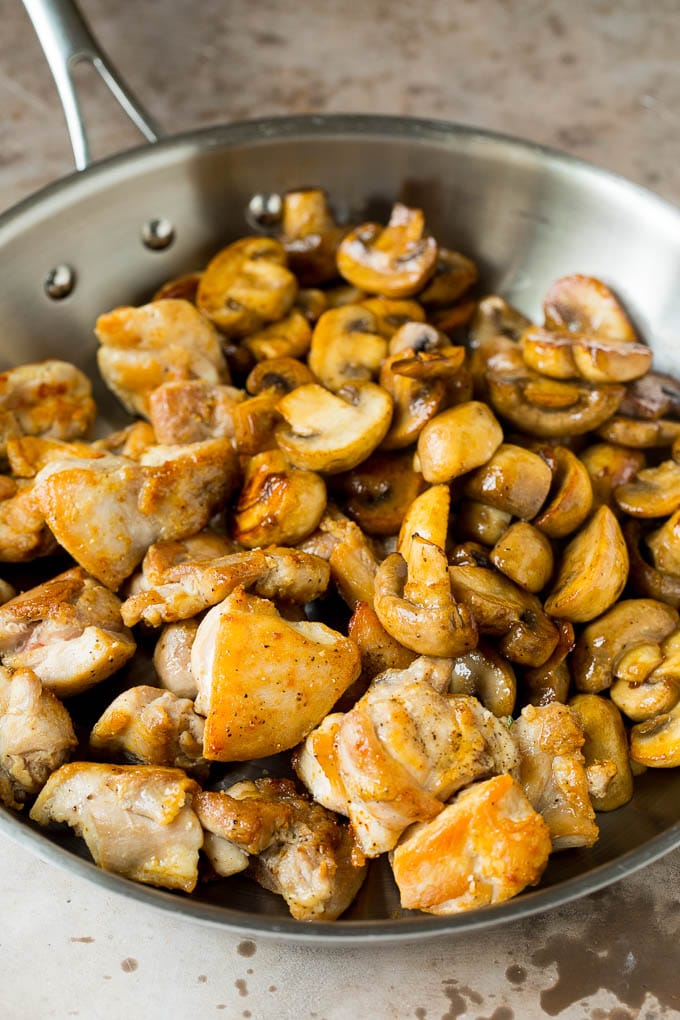 Cooked chicken and sauteed mushrooms together in a pan.