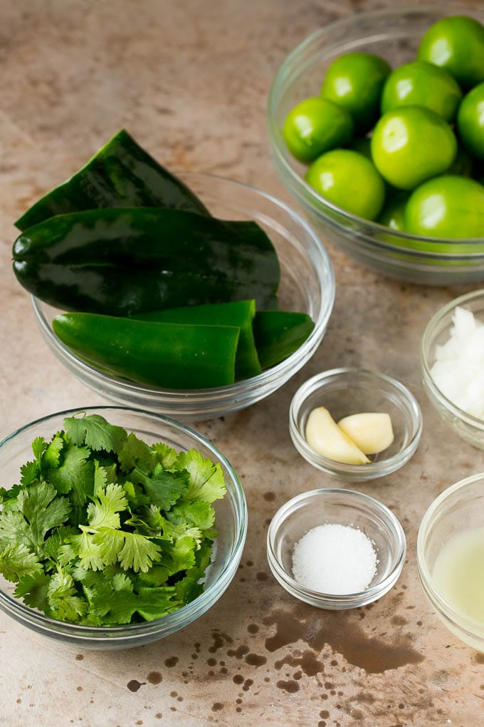 Bowls of tomatillos, peppers, garlic, cilantro and seasonings.