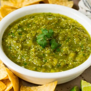 A bowl of salsa verde served with tortilla chips.