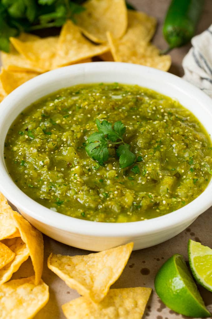 A bowl of salsa verde served with tortilla chips.