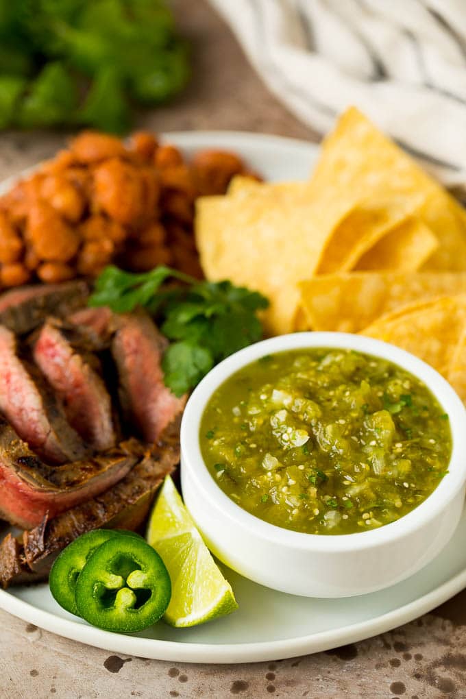 Salsa verde served with carne asada, beans and tortillas.