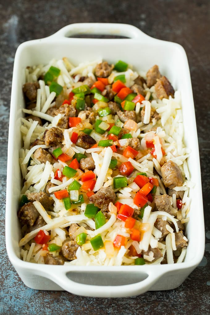 Hash browns, sausage and peppers in a baking dish.