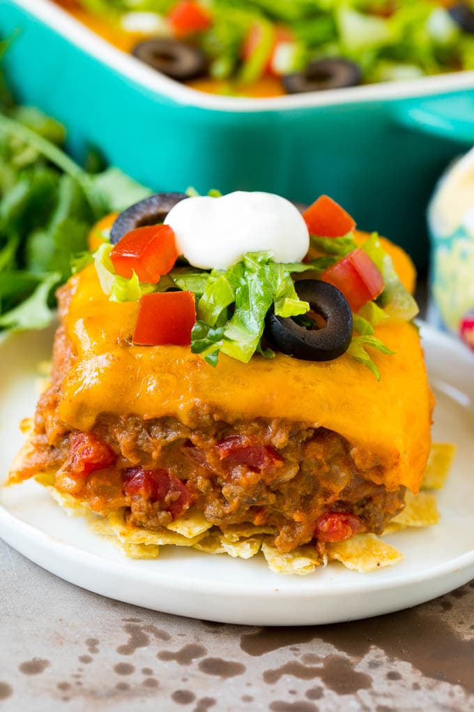 A slice of taco bake with a crust of tortilla chips and a filling of beef and beans.