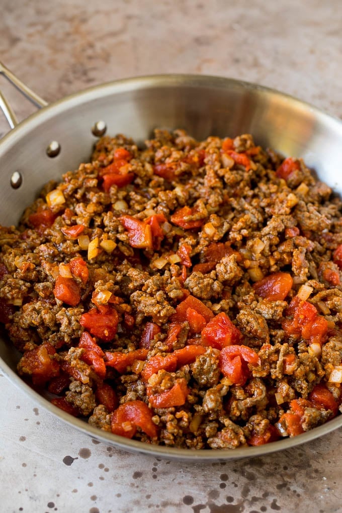 Ground beef, tomatoes and seasoning in a pan.