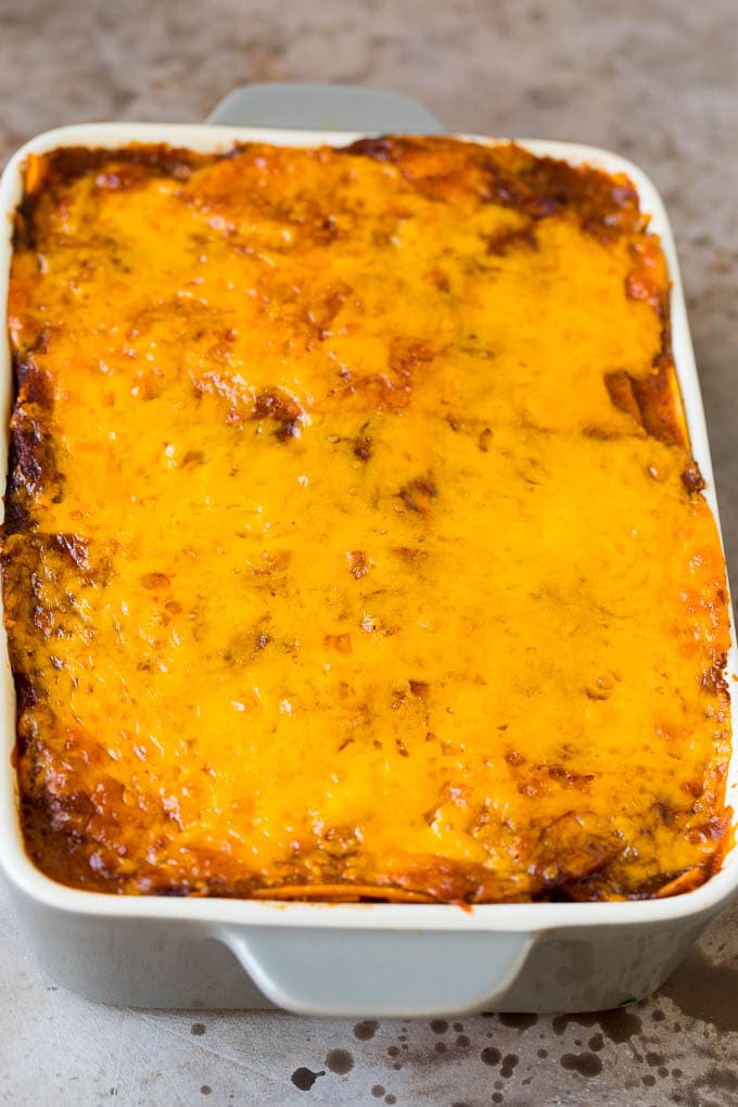 A baked casserole with layers of tortillas, meat and cheese.