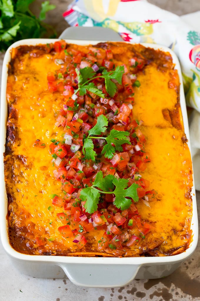 A pan of taco lasagna topped with fresh salsa and cilantro.