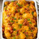 Tater tot breakfast casserole topped with bacon and green onions.