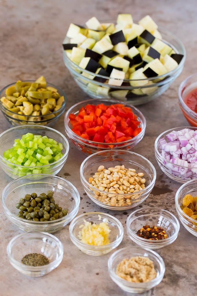 Bowls of ingredients including diced vegetables, olives, raisins and seasonings.