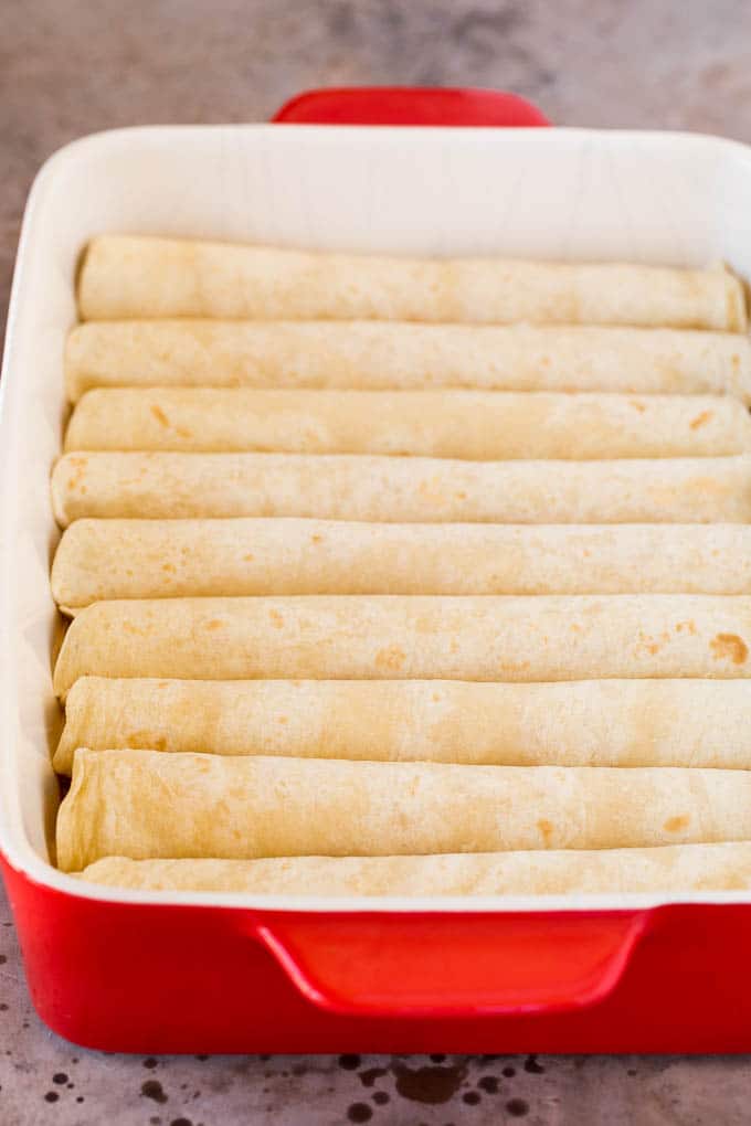 Cheese rolled up inside tortillas in a dish.