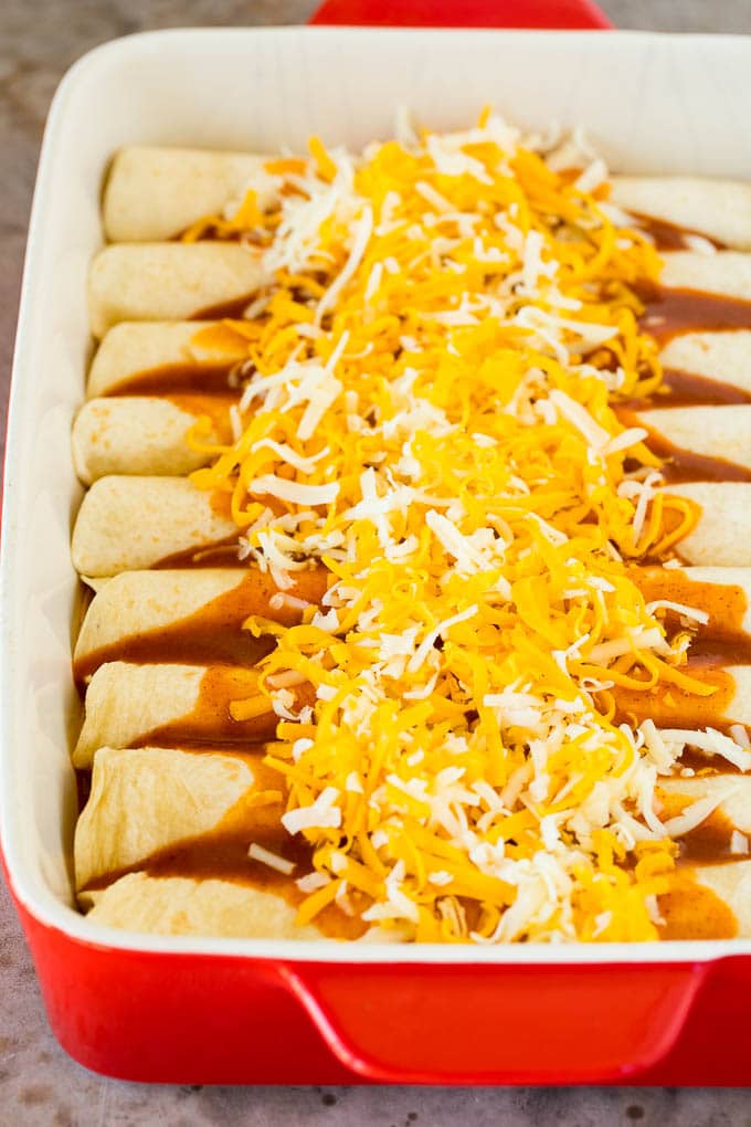 Tortilla rolls topped with sauce and cheese.