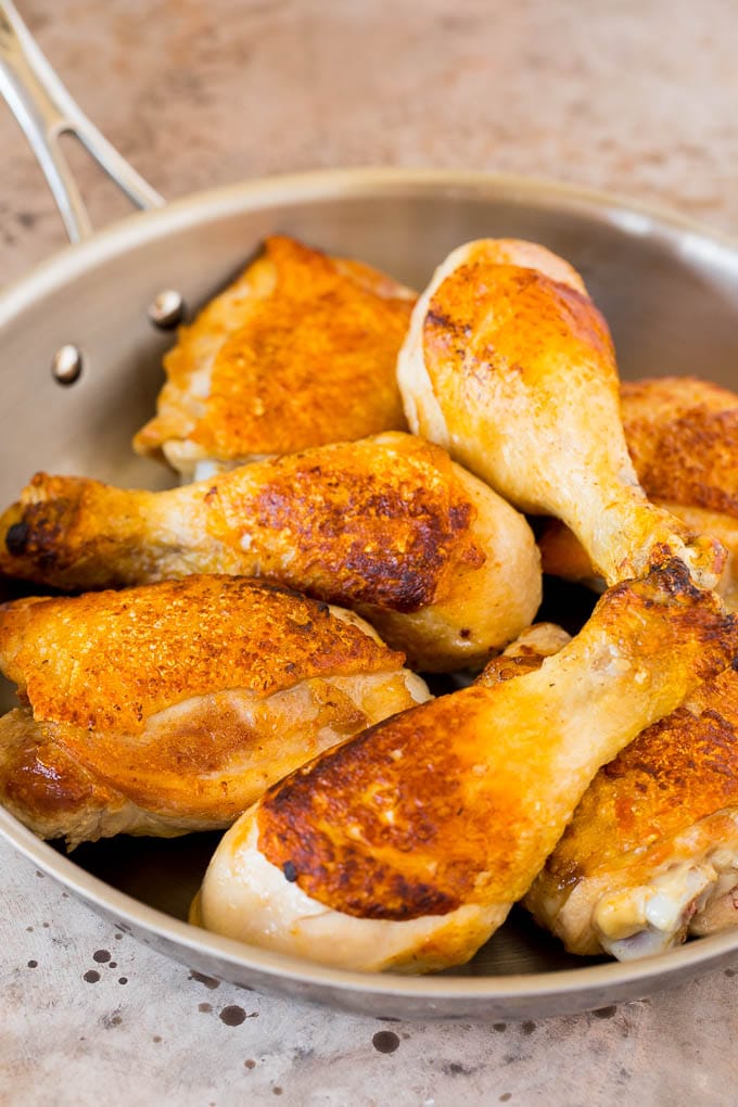 Browned chicken pieces in a skillet.